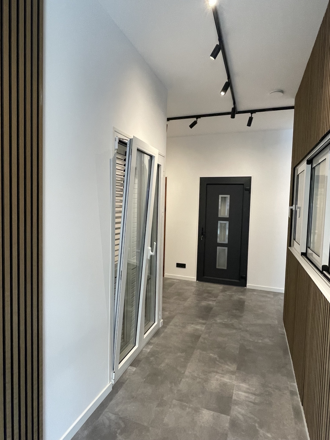 Doorkijk in de showroom met kunststof raam, rolluik en zwarte voordeur